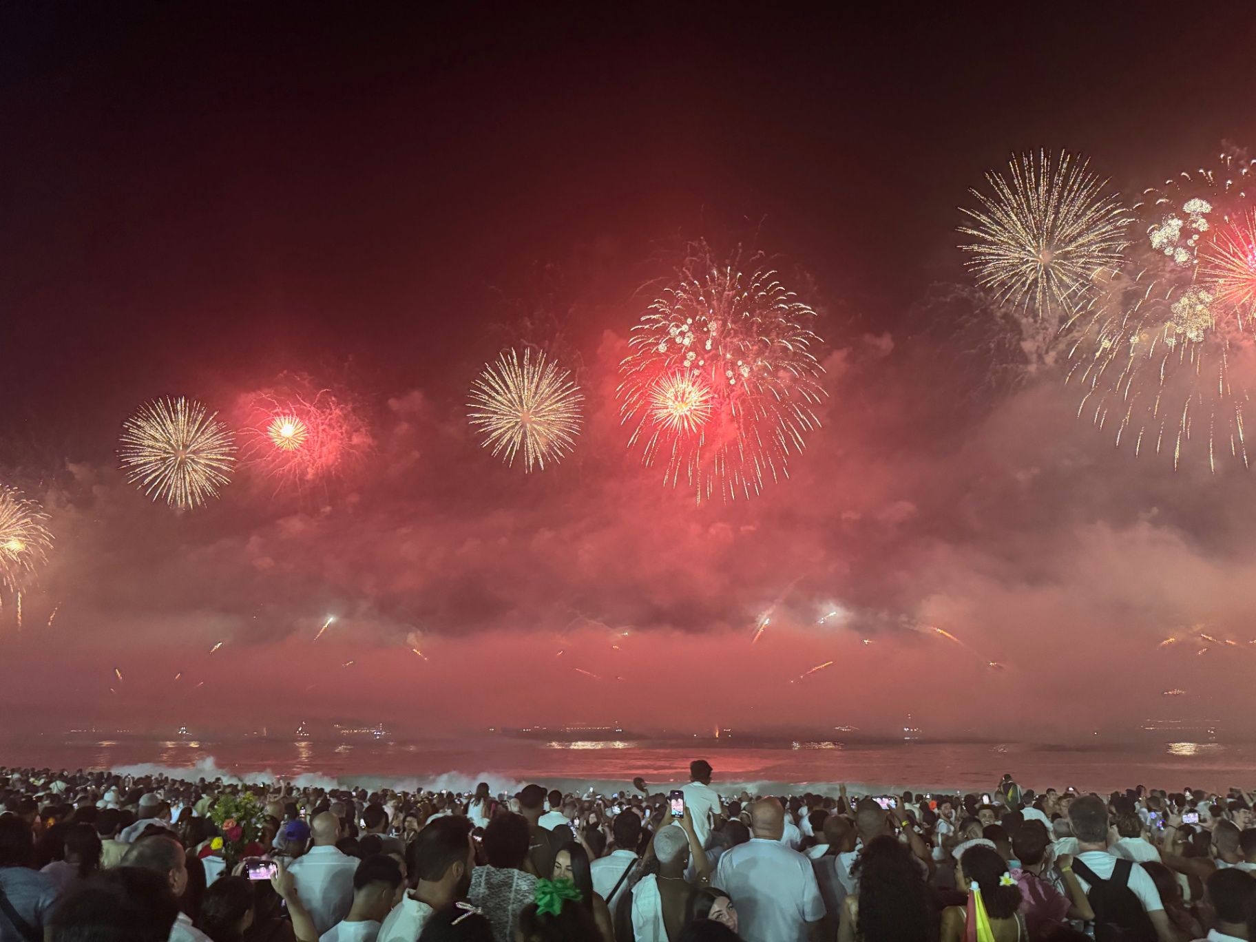 Rio de Janeiro — New Year's Eve fireworks burning red over Copacabana.
