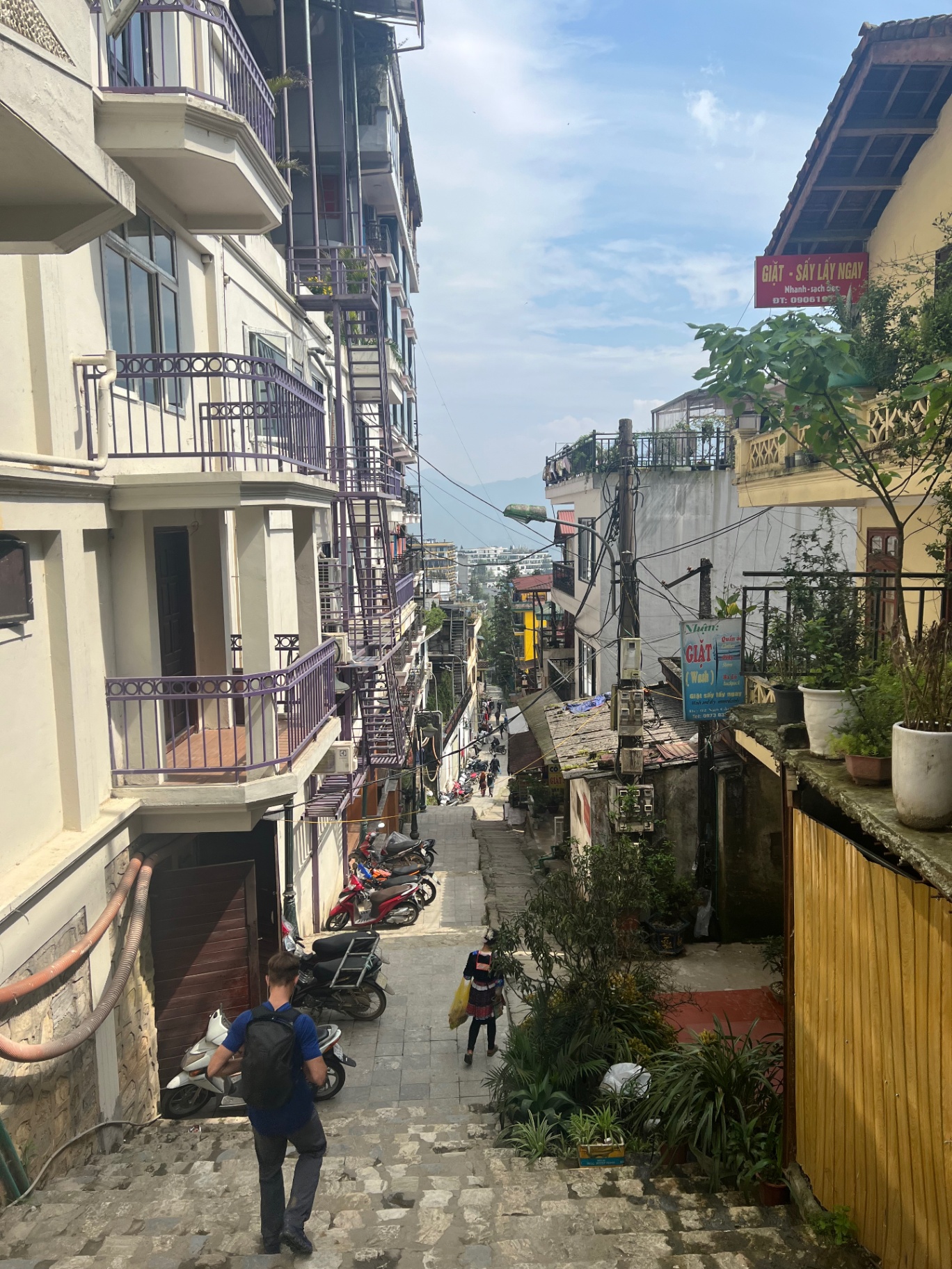 Sa Pa — Steep town steps tangled in wires and parked scooters.