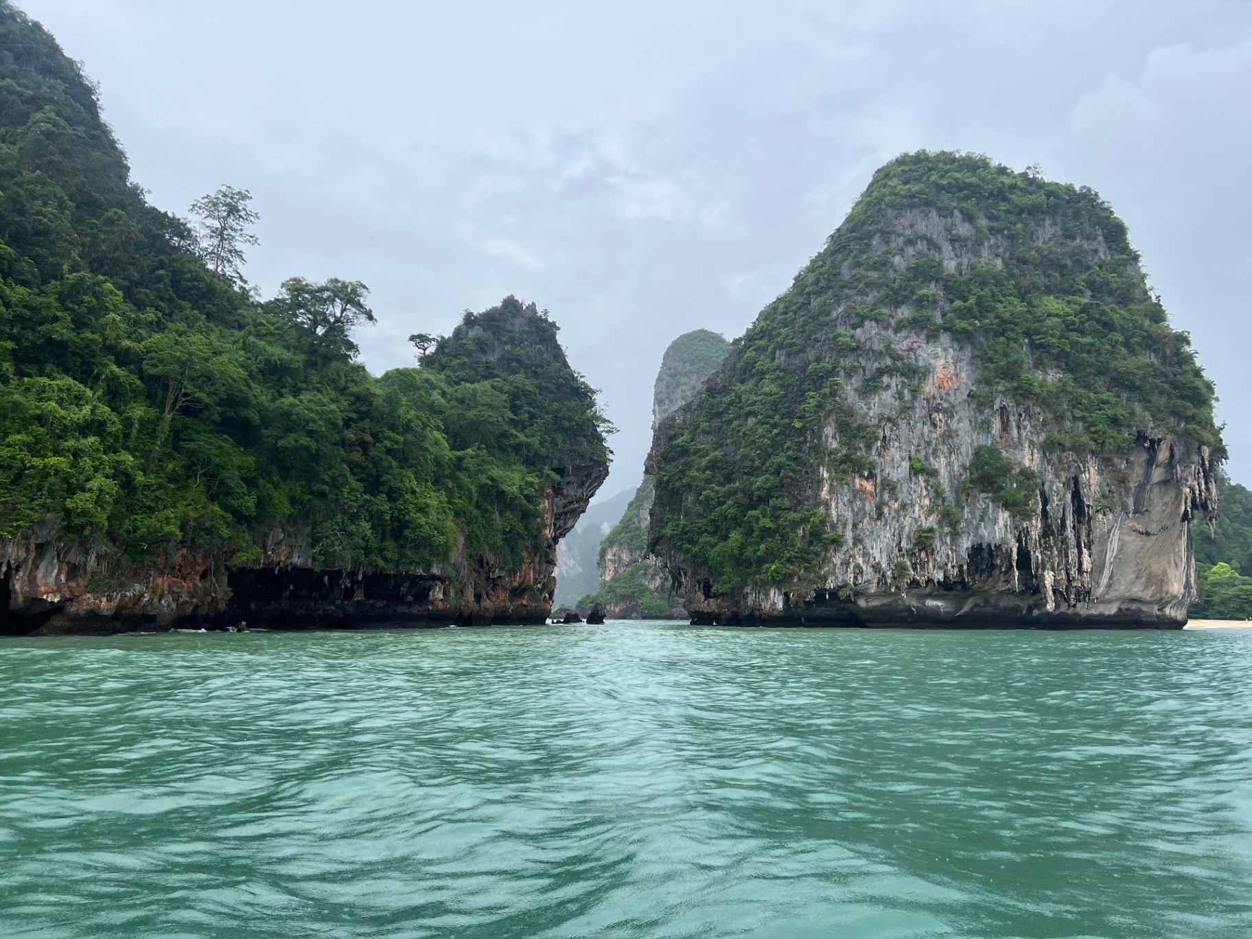 Krabi — Limestone cliffs rising straight from jade water in the bay.
