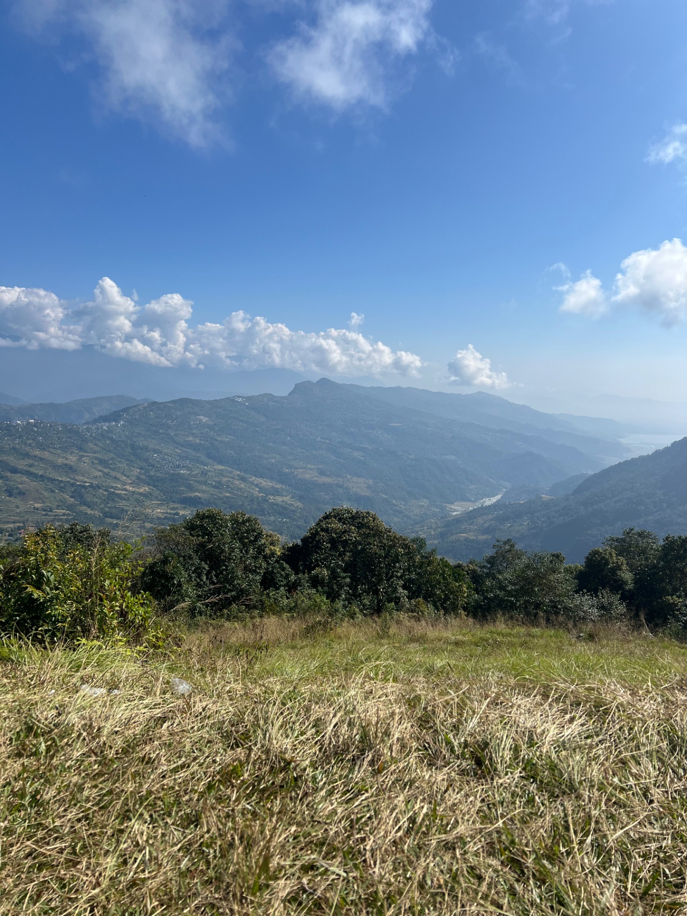 Pokhara — Wide Himalayan foothill view with the river glinting far below.