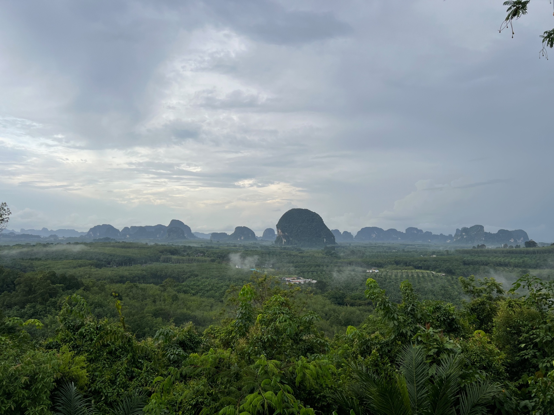 Krabi — Storm light rolling over the karst-dotted inland valley.