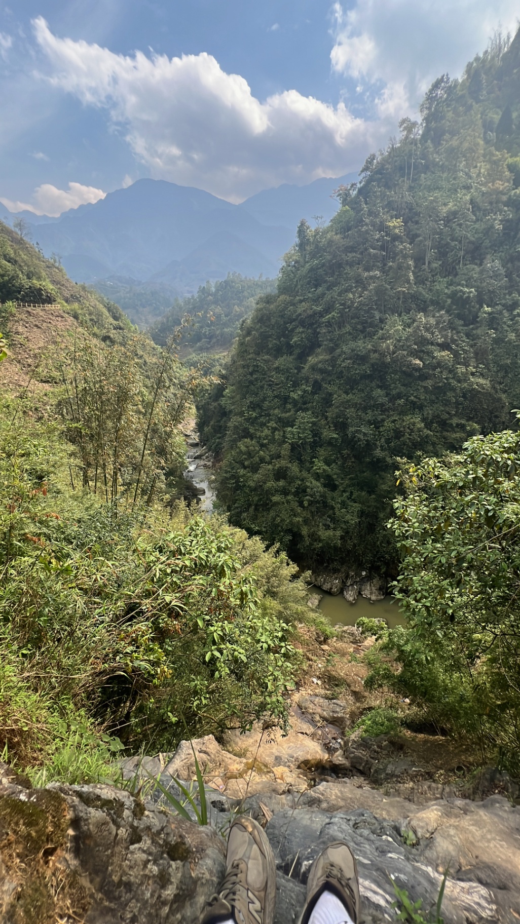 Sa Pa — Boots on the rock, river snaking through the valley below.
