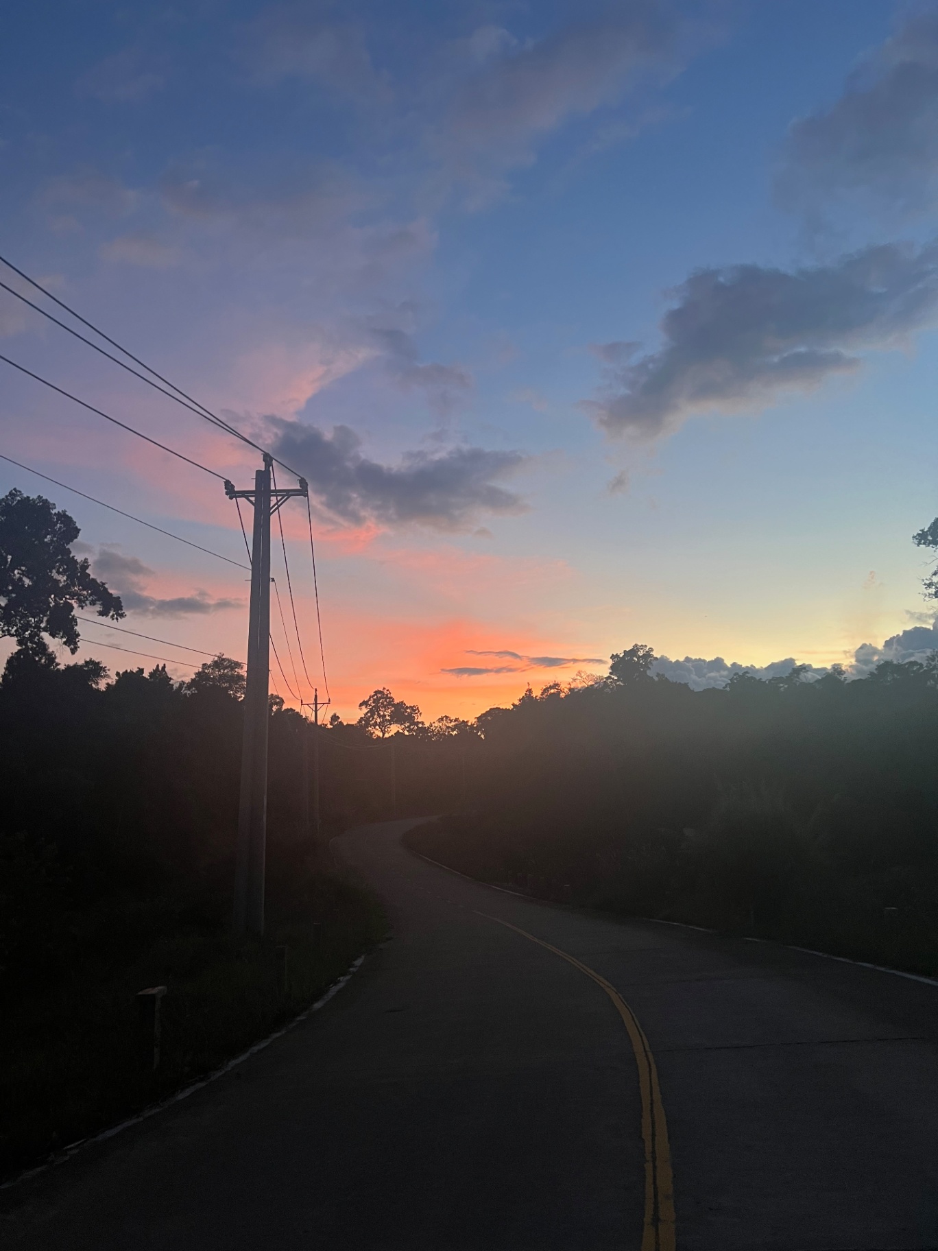 Phu Quoc — An empty island road fading into a pink-and-orange dusk.