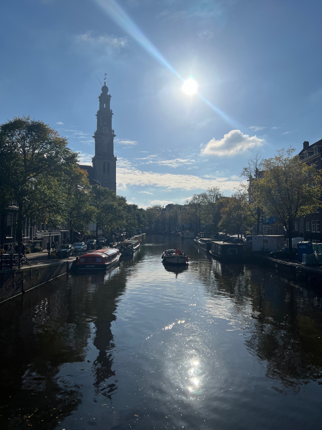 Amsterdam — Sun over the canal, boats drifting past.