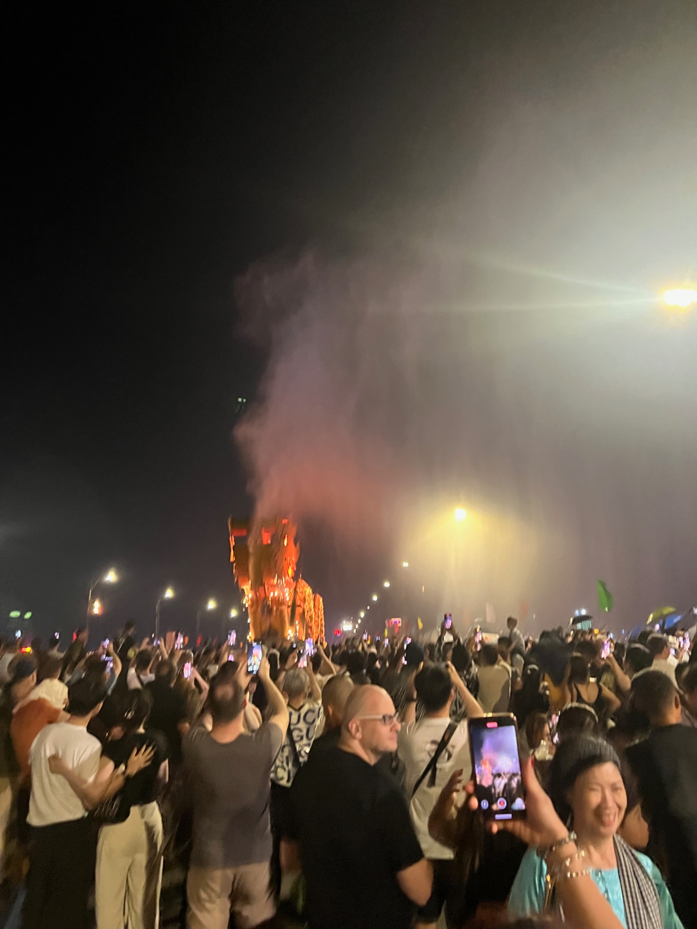 Da Nang — Crowds with phones held high as a Tet effigy burns.