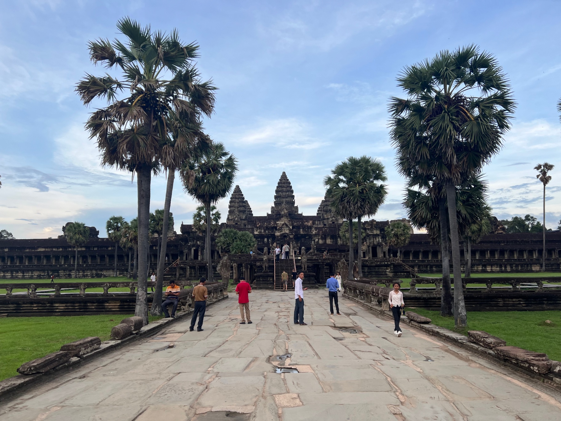 Siem Reap — Walking the causeway toward Angkor Wat at dawn.