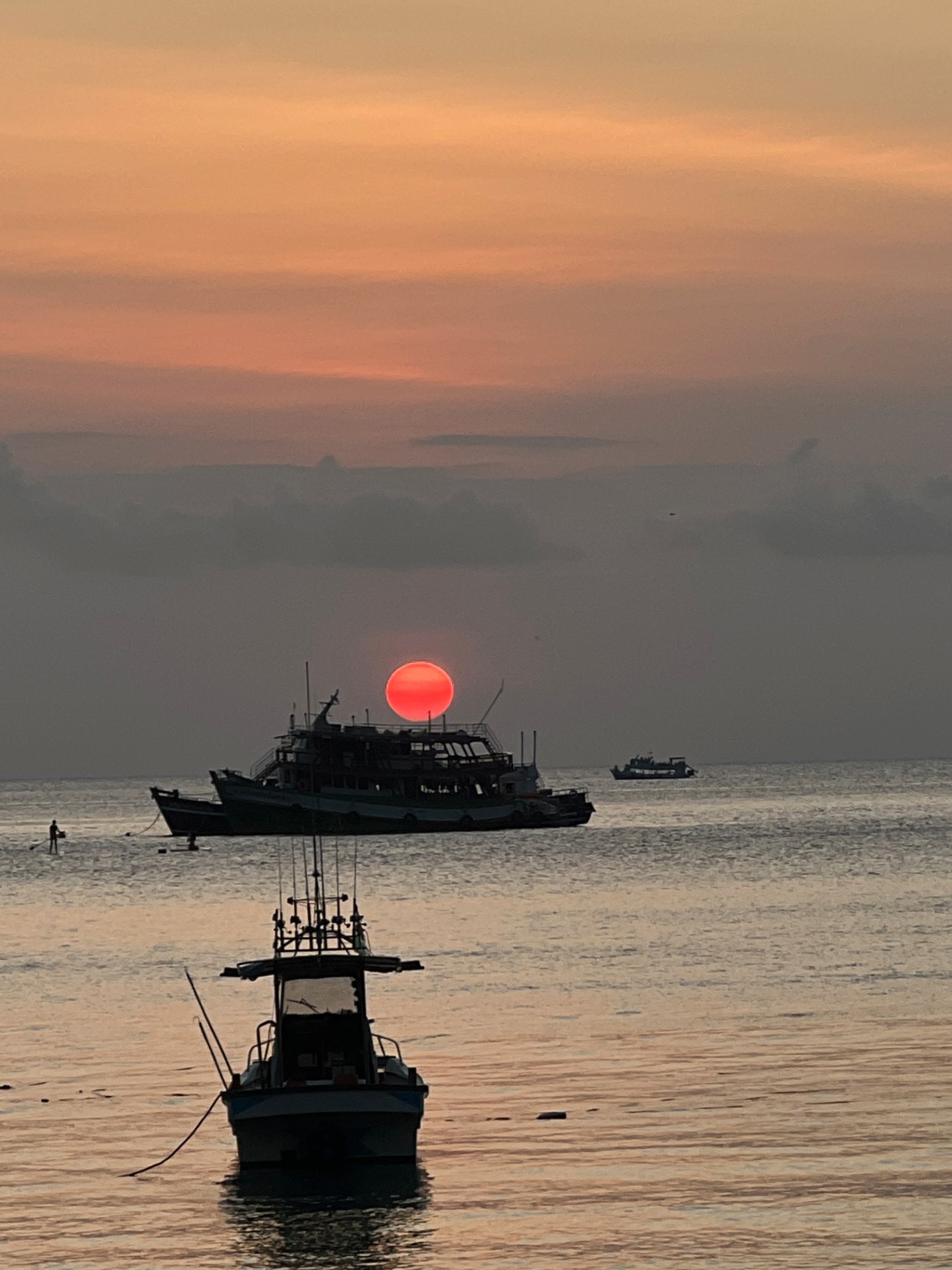 Ko Tao — Blood-red sun dropping behind a dive boat off Sairee Beach.