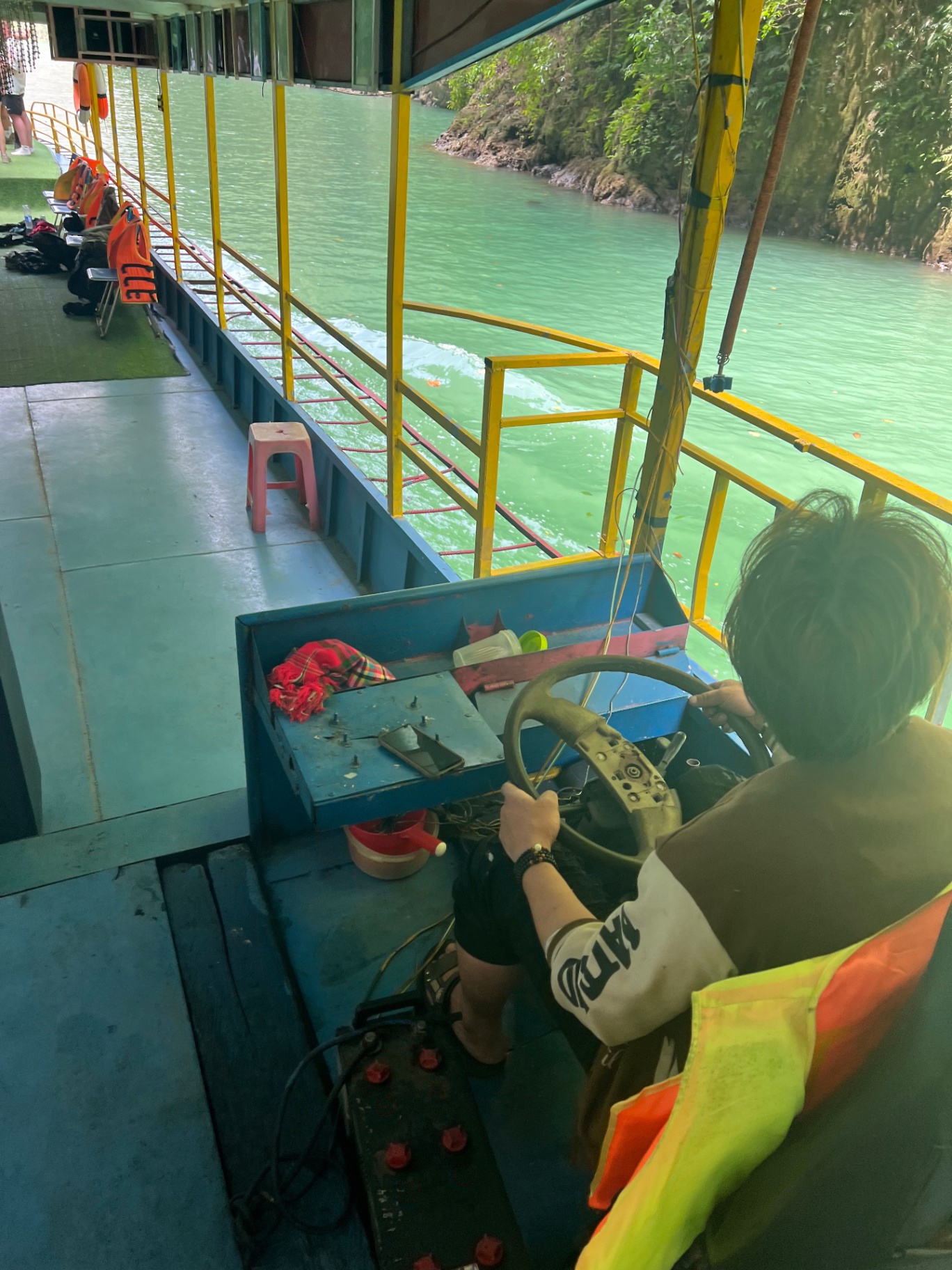Ha Giang — Heading downriver on a longtail through emerald water.