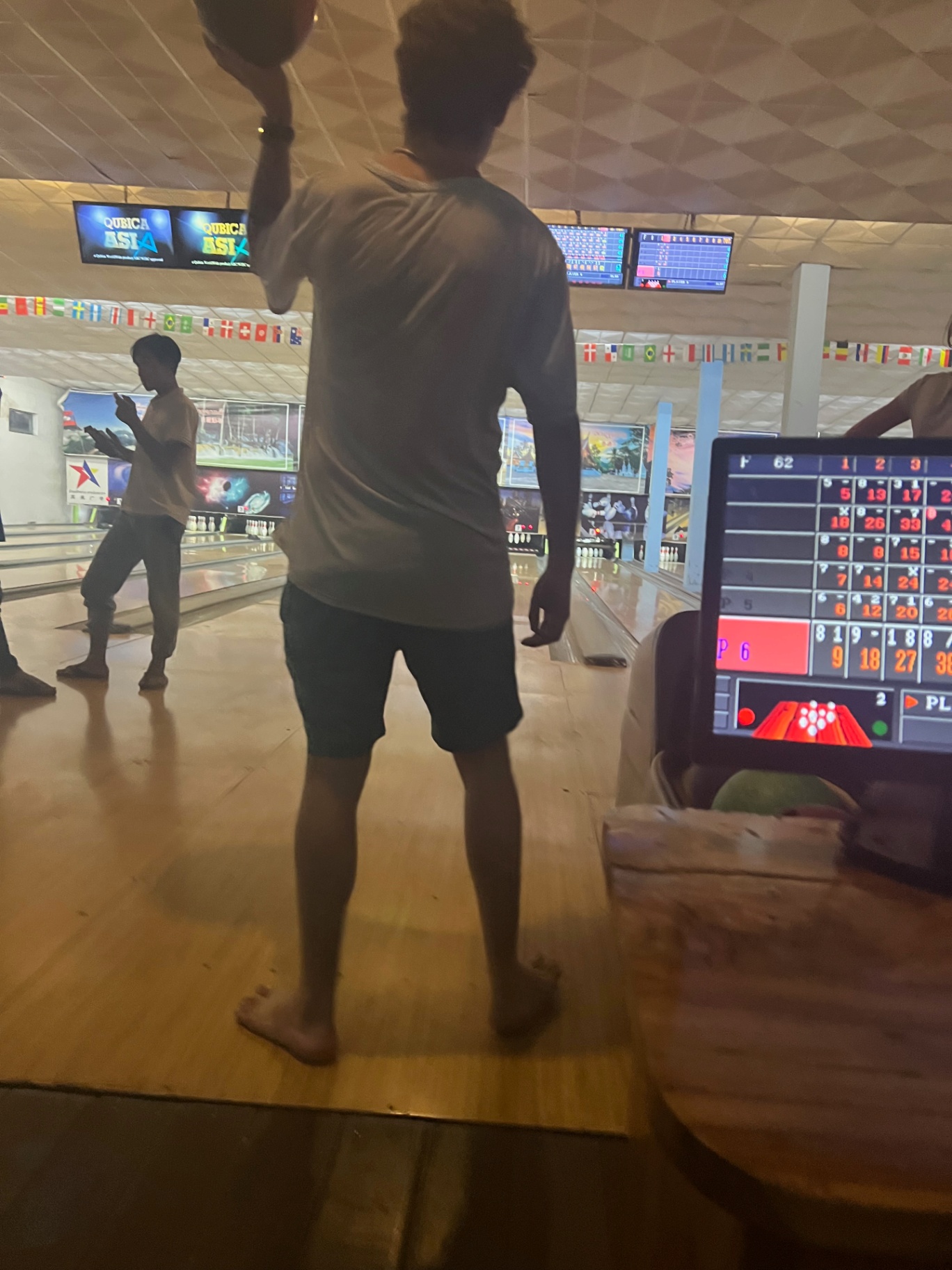 Luang Prabang — Late-night bowling under flags of the world.