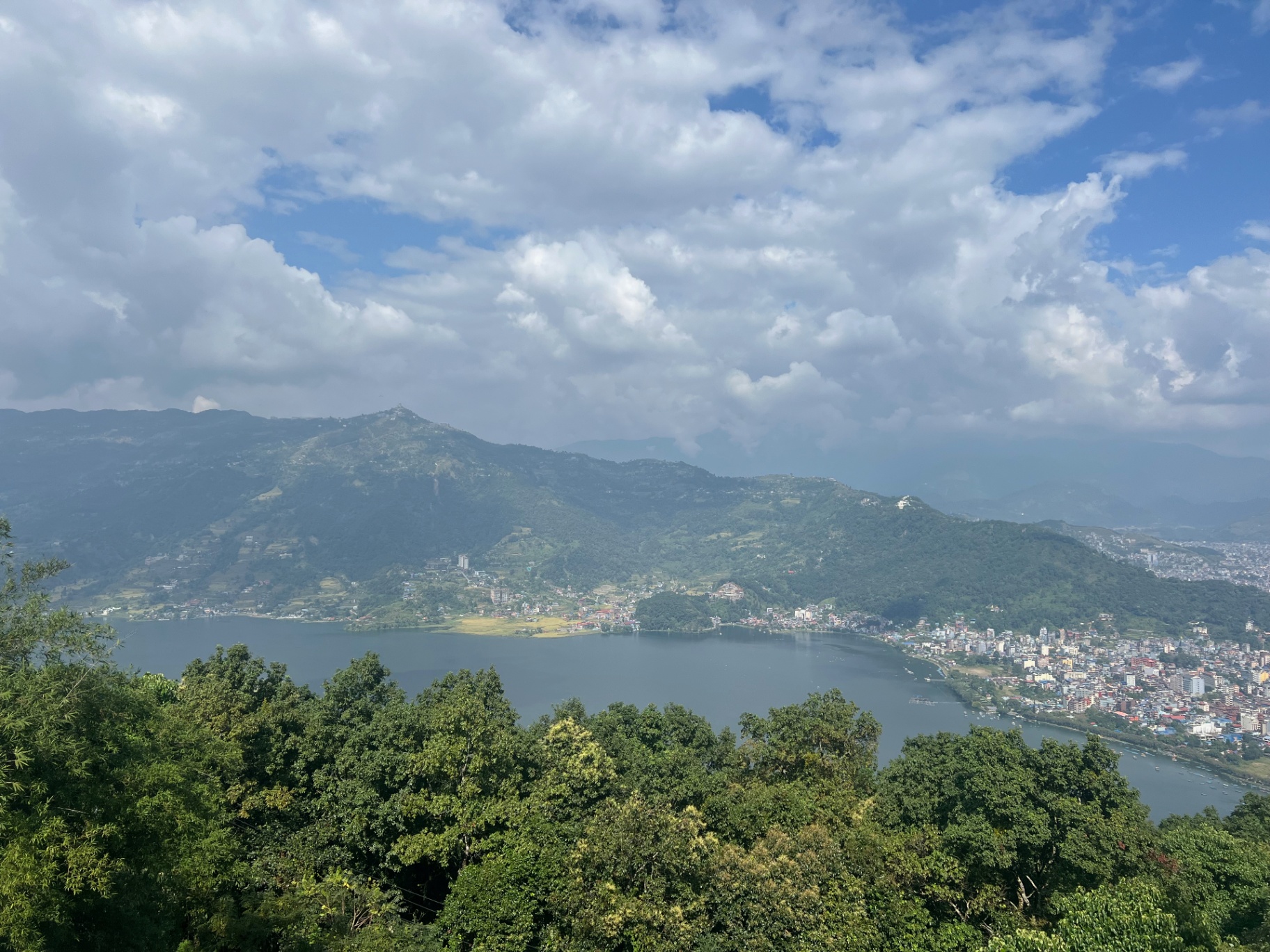 Pokhara — Phewa Lake and Pokhara spread out beneath towering monsoon clouds.