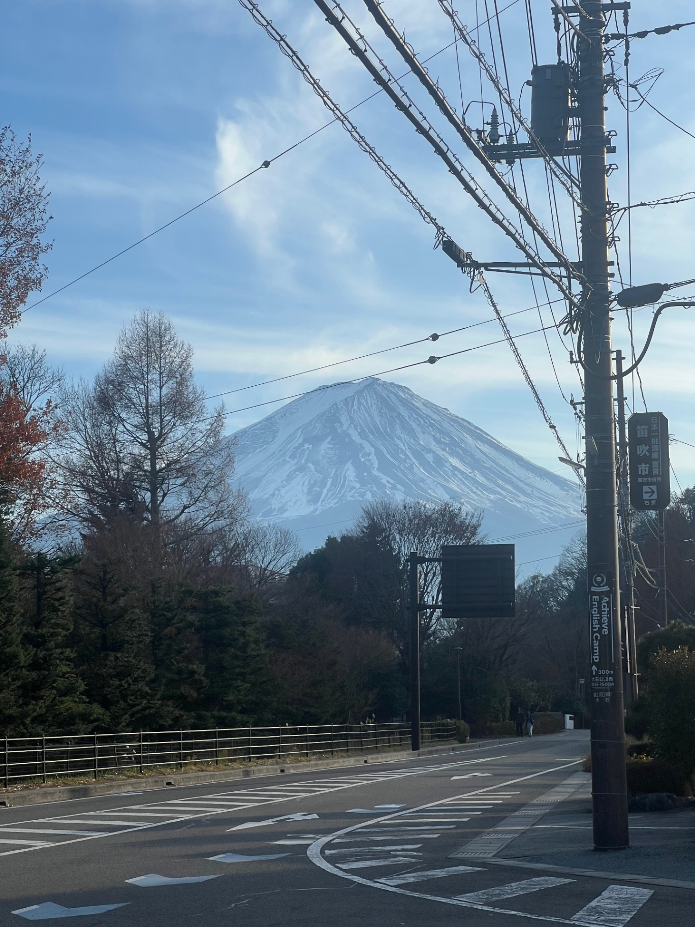 Mount Fuji — Fuji-san framed between power lines on a quiet street.