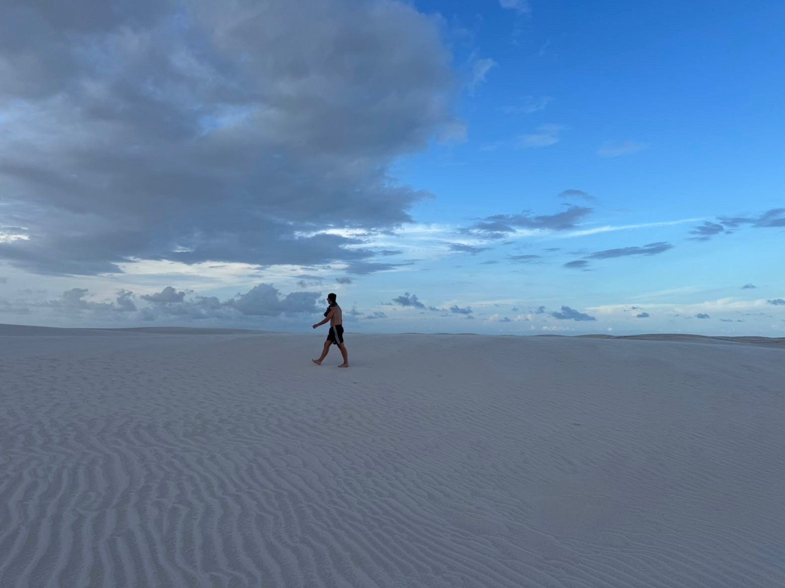 Lencois Maranhenses — Barefoot across the white sands at dusk.