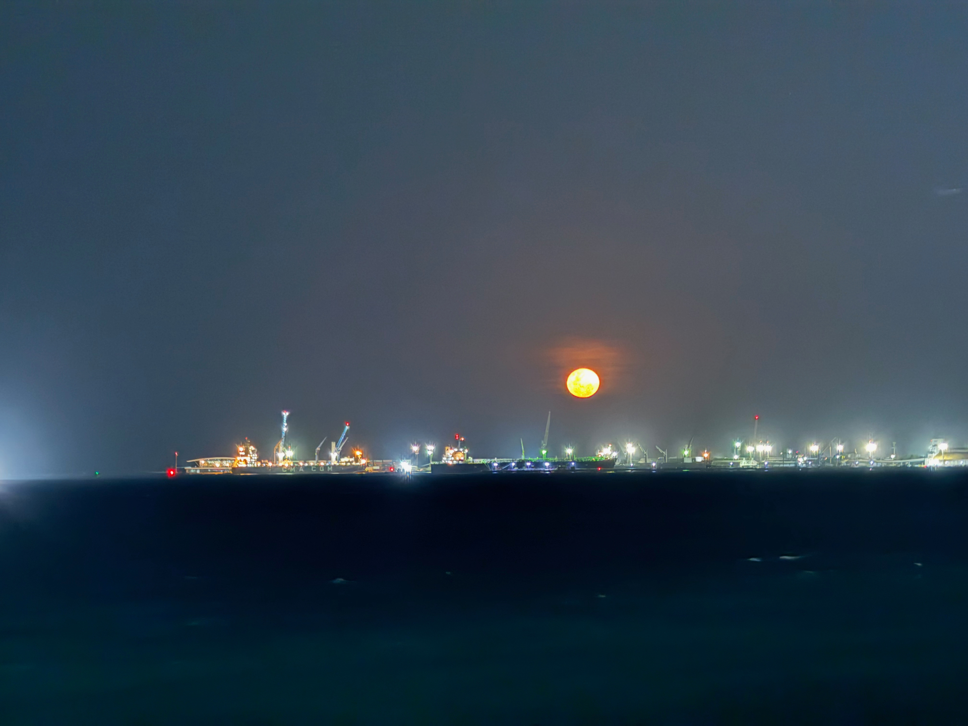 Fortaleza — Full moon rising over the port at night.