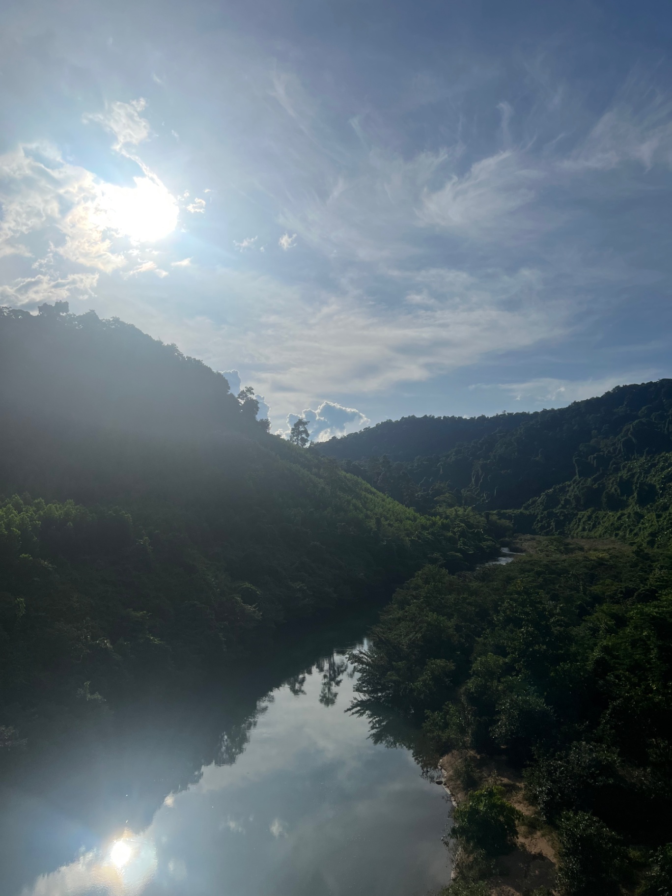 Phong Nha — Sun glare over the river cutting through Phong Nha's jungle valley.