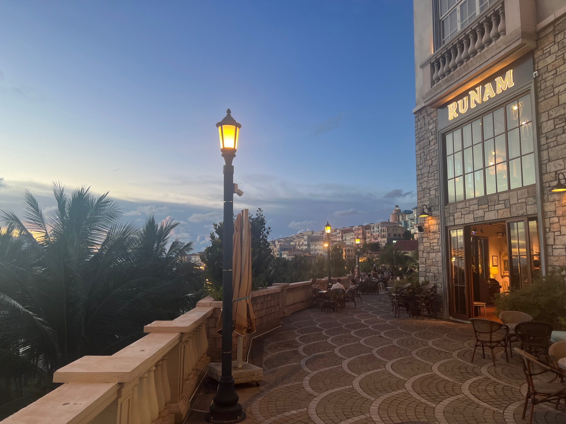 Phu Quoc — Blue-hour promenade lights glowing outside the waterfront bars.