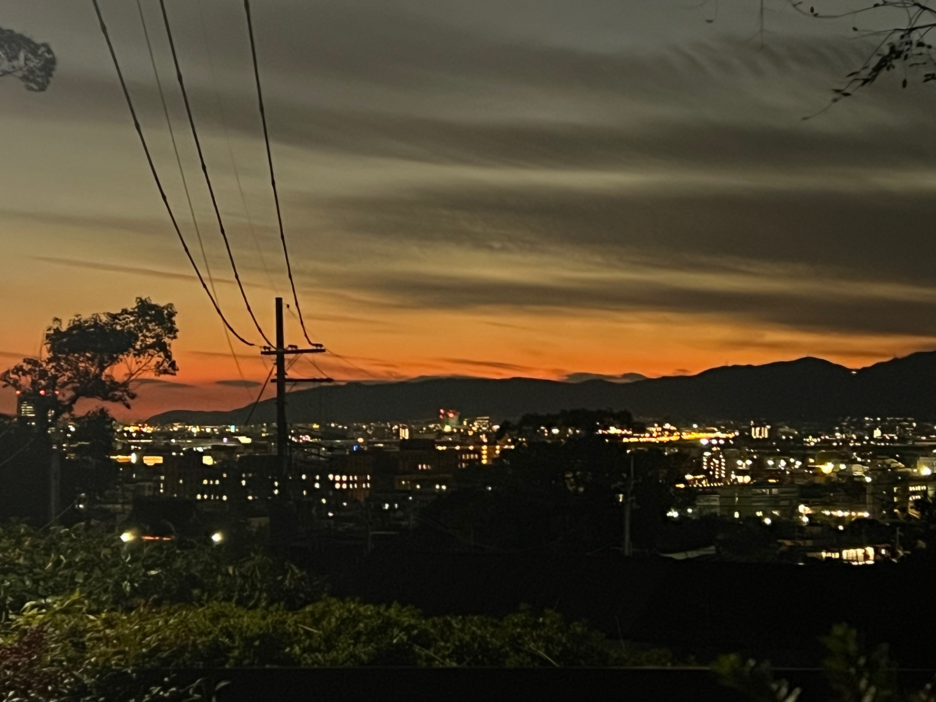 Kyoto — Kyoto lights flickering beneath a warm sunset ridge.