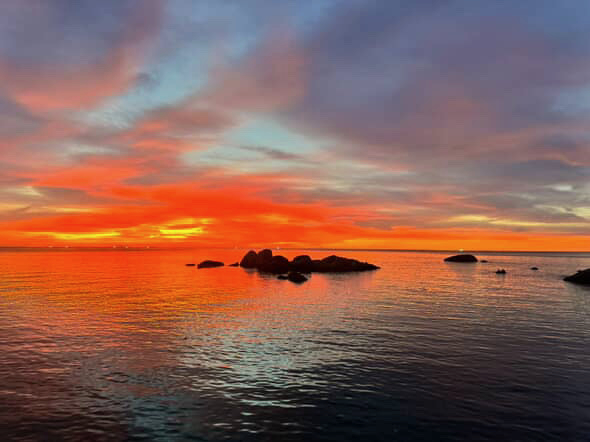 Ko Tao — Layered clouds glowing orange above the calm sea.