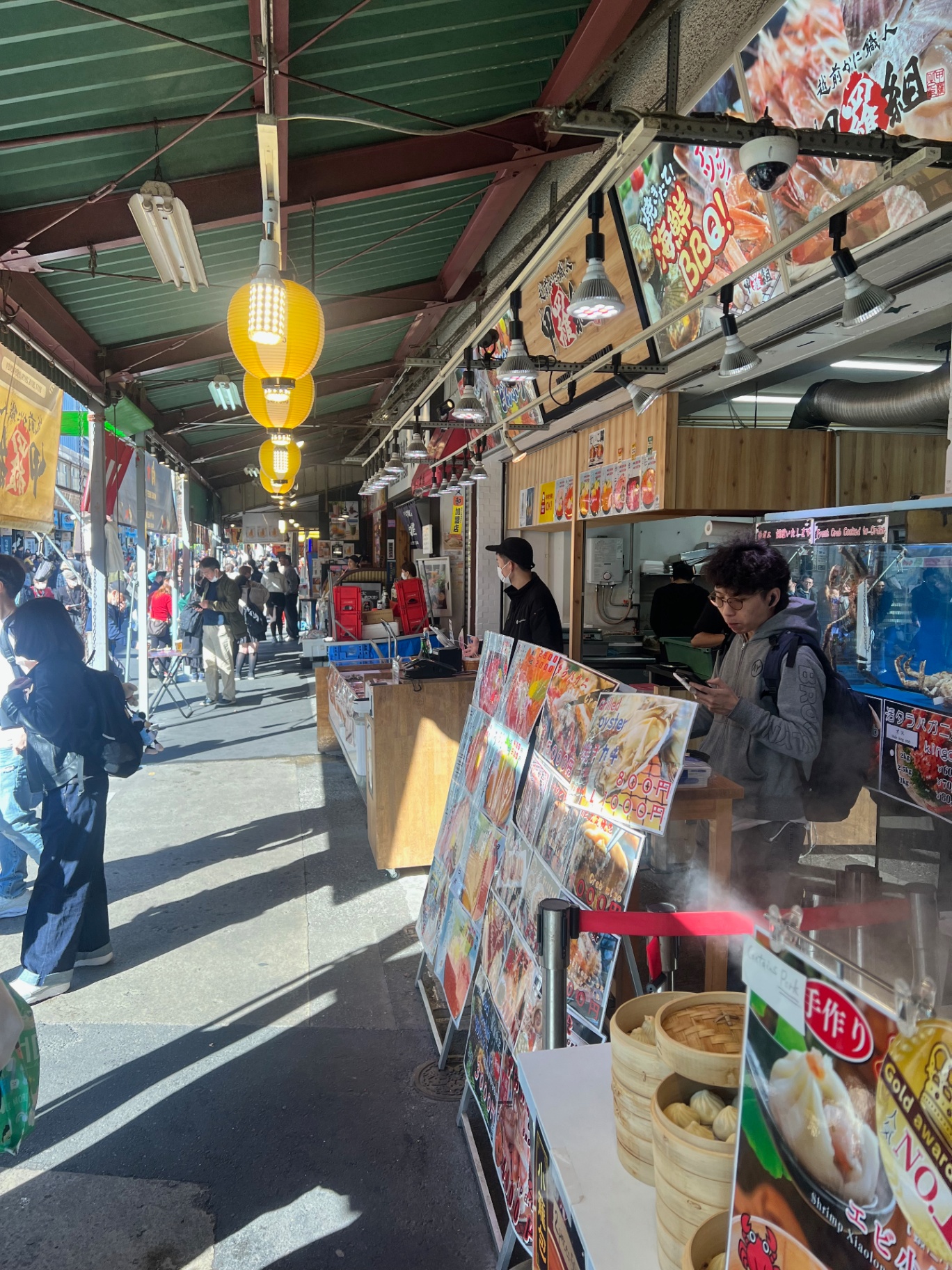 Tokyo — Lantern-lit market arcade packed with menus, steam, and lunchtime traffic.