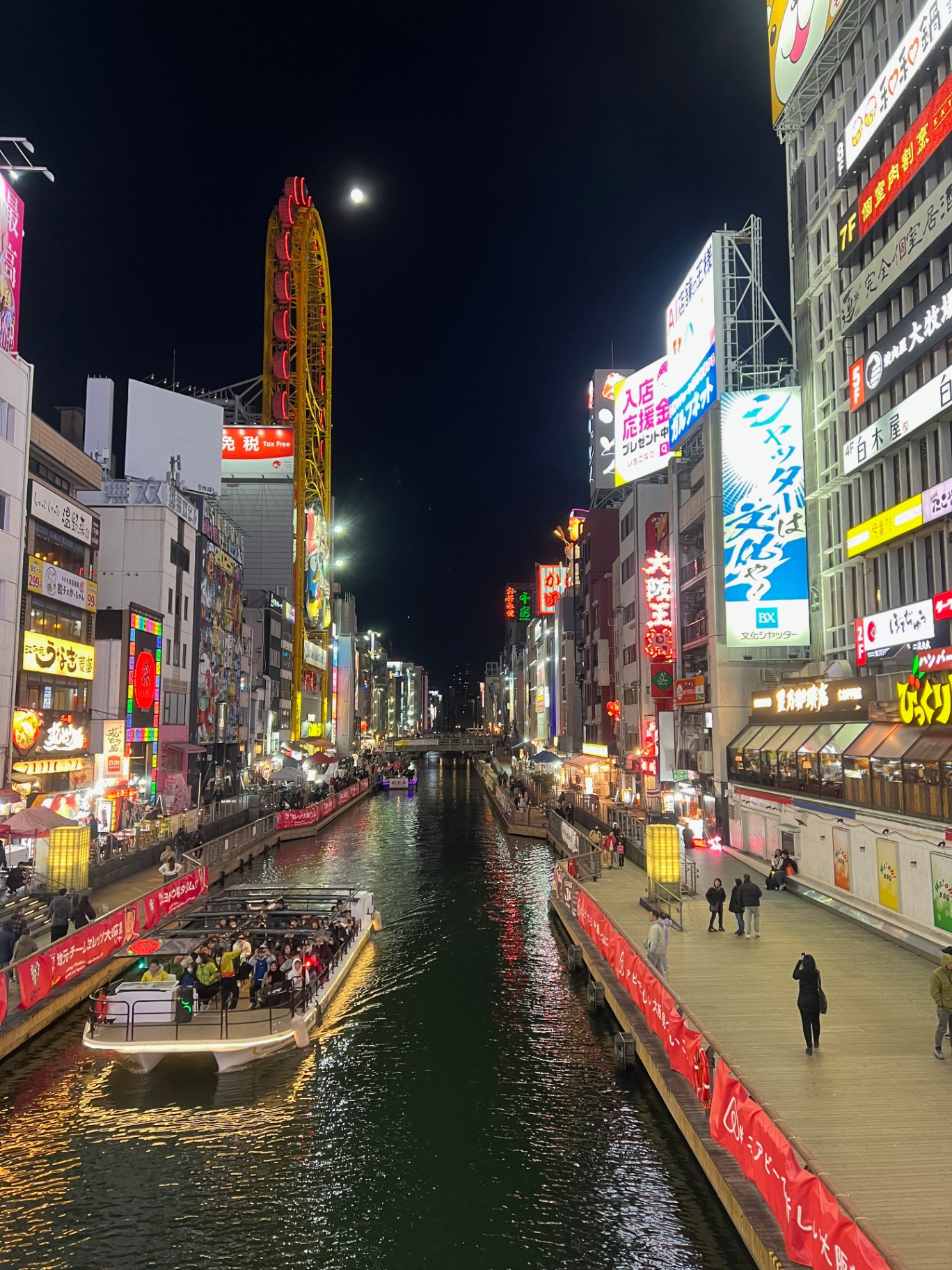 Osaka — Full moon over the ferris wheel along the Dotonbori canal.
