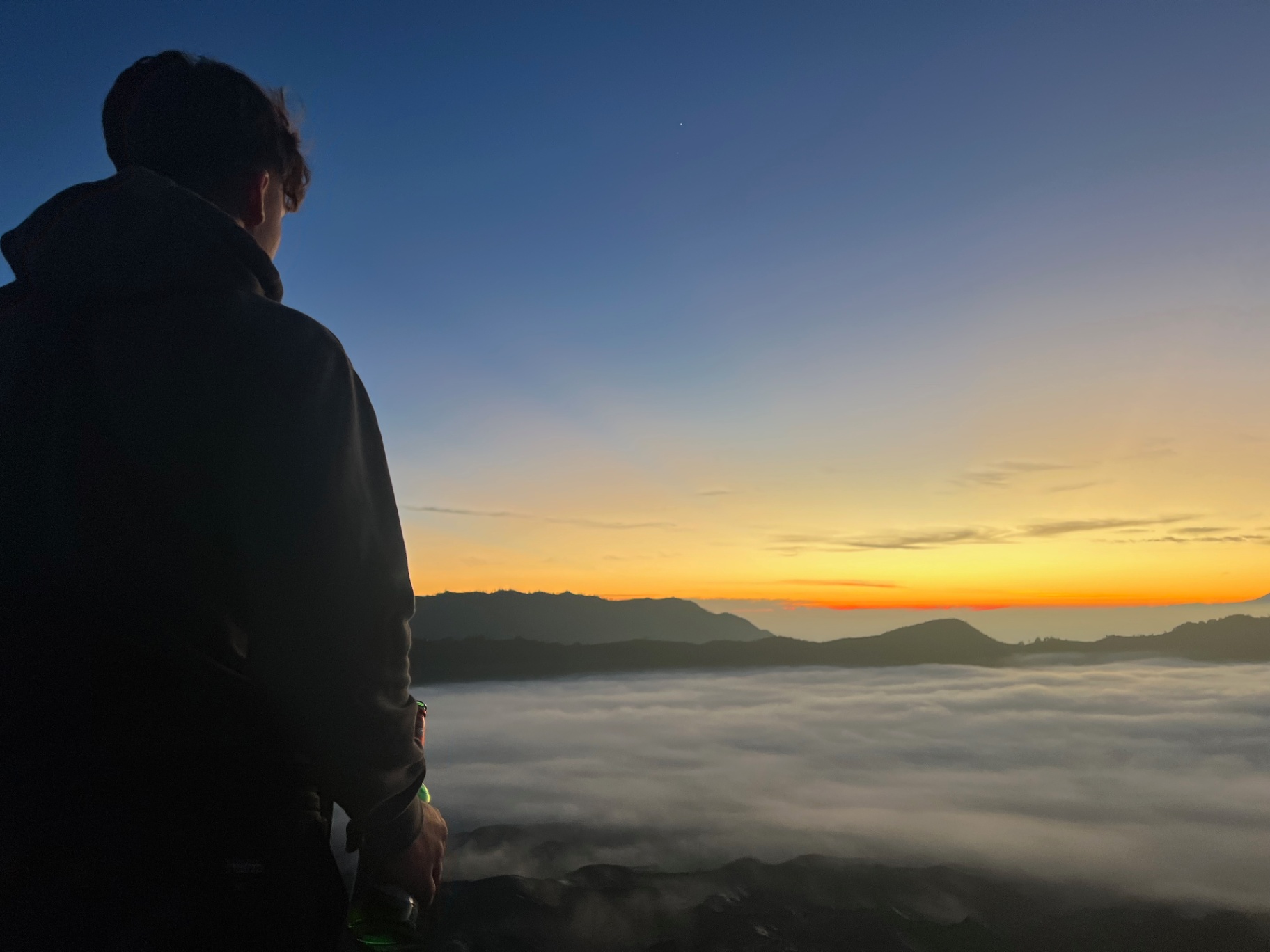 Mount Bromo — First orange band of sunrise over a sea of clouds.