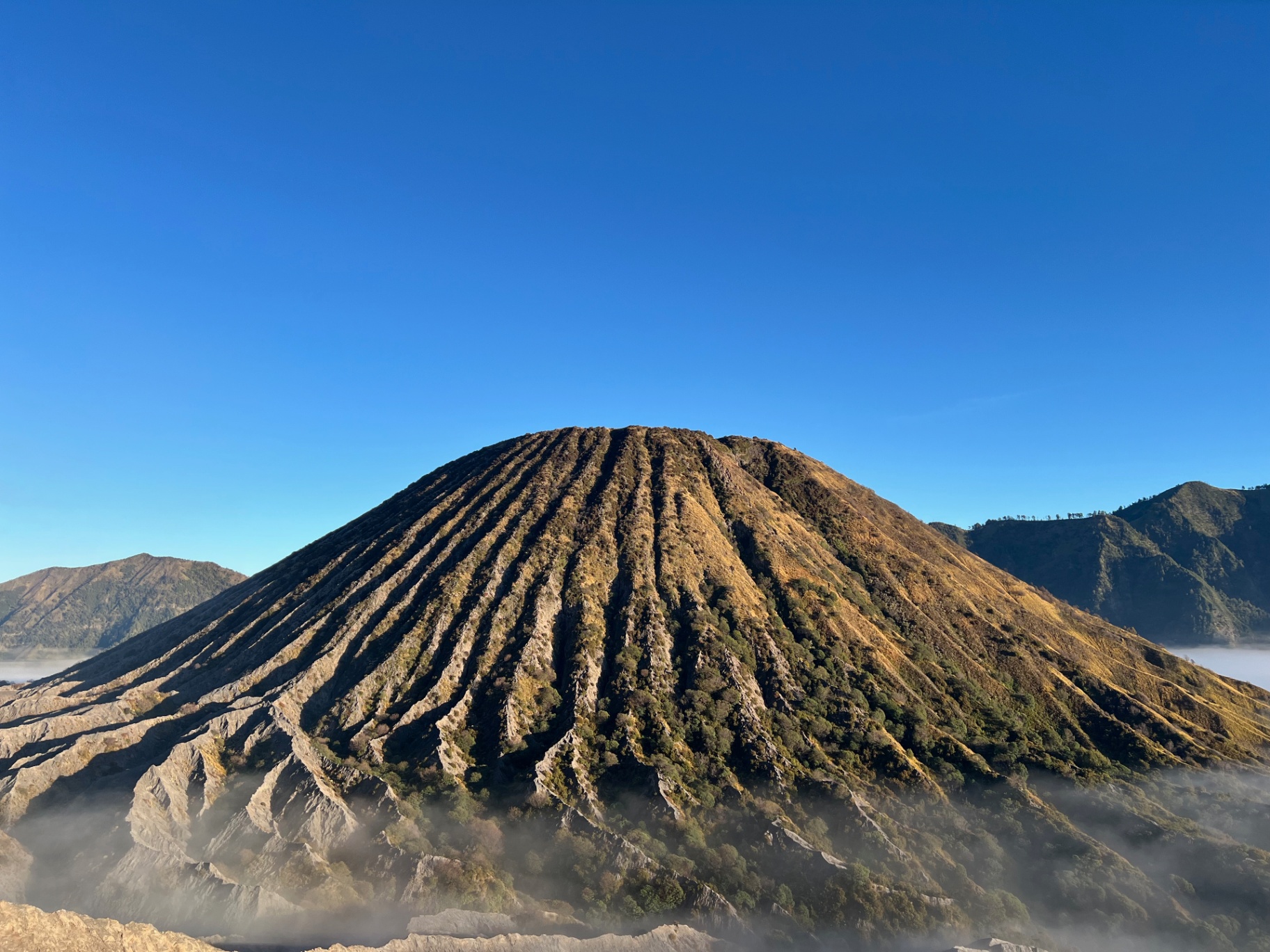 Mount Bromo — Mount Batok's ridged flanks under a deep blue sky.