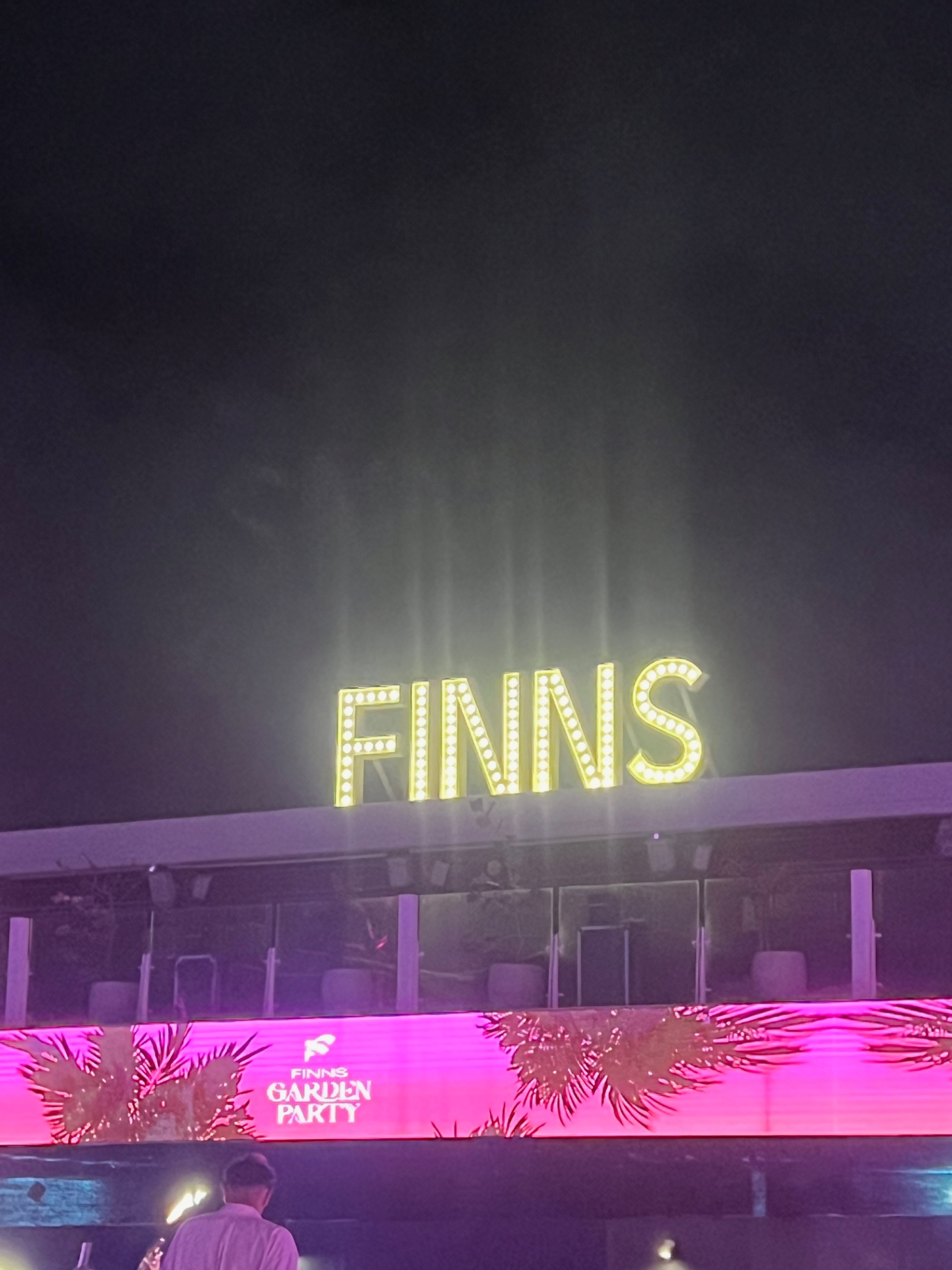 Bali — Finns Beach Club marquee glowing over a Bali night.