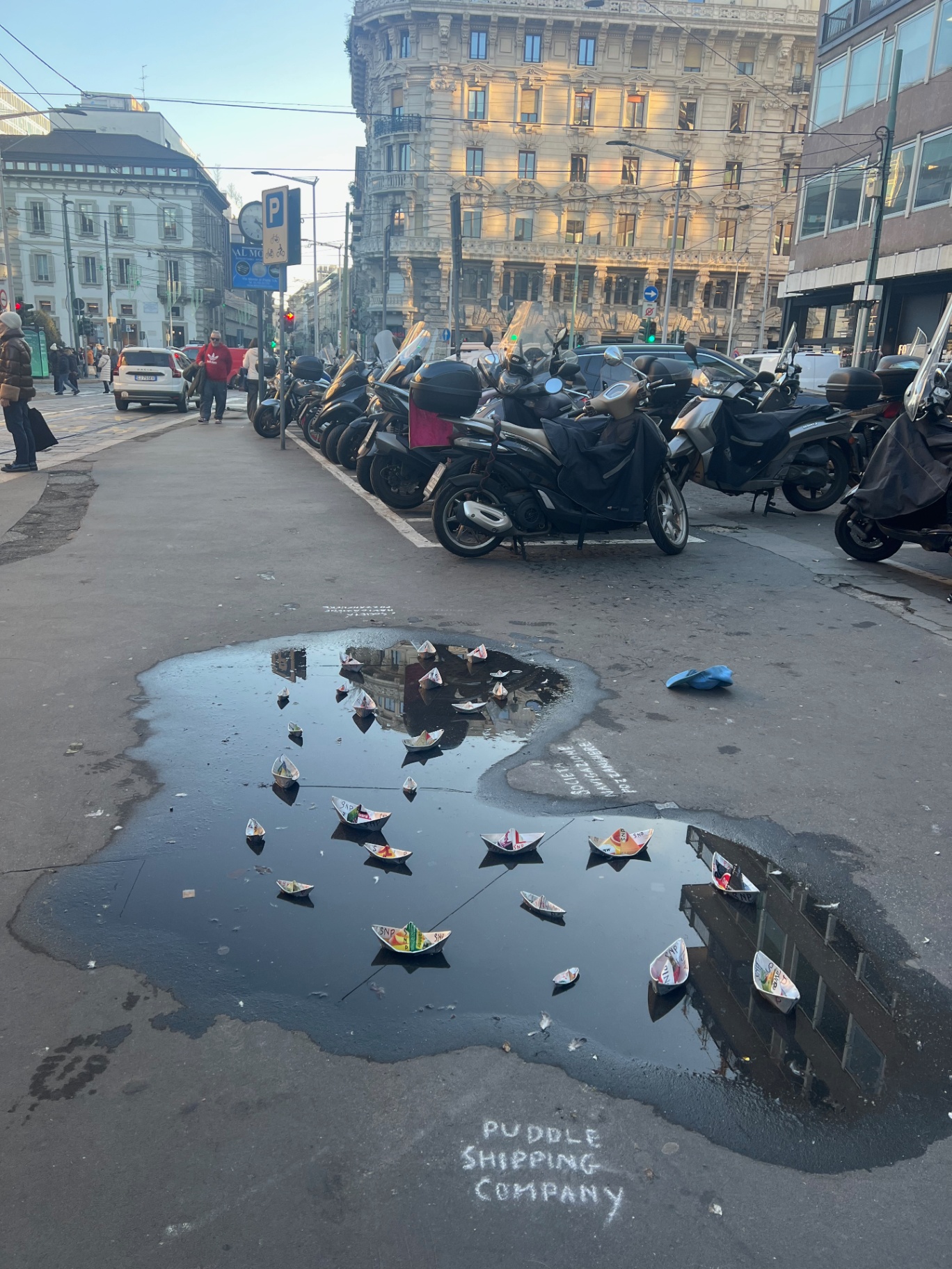 Milan — Puddle Shipping Company — paper boats sailing the street.