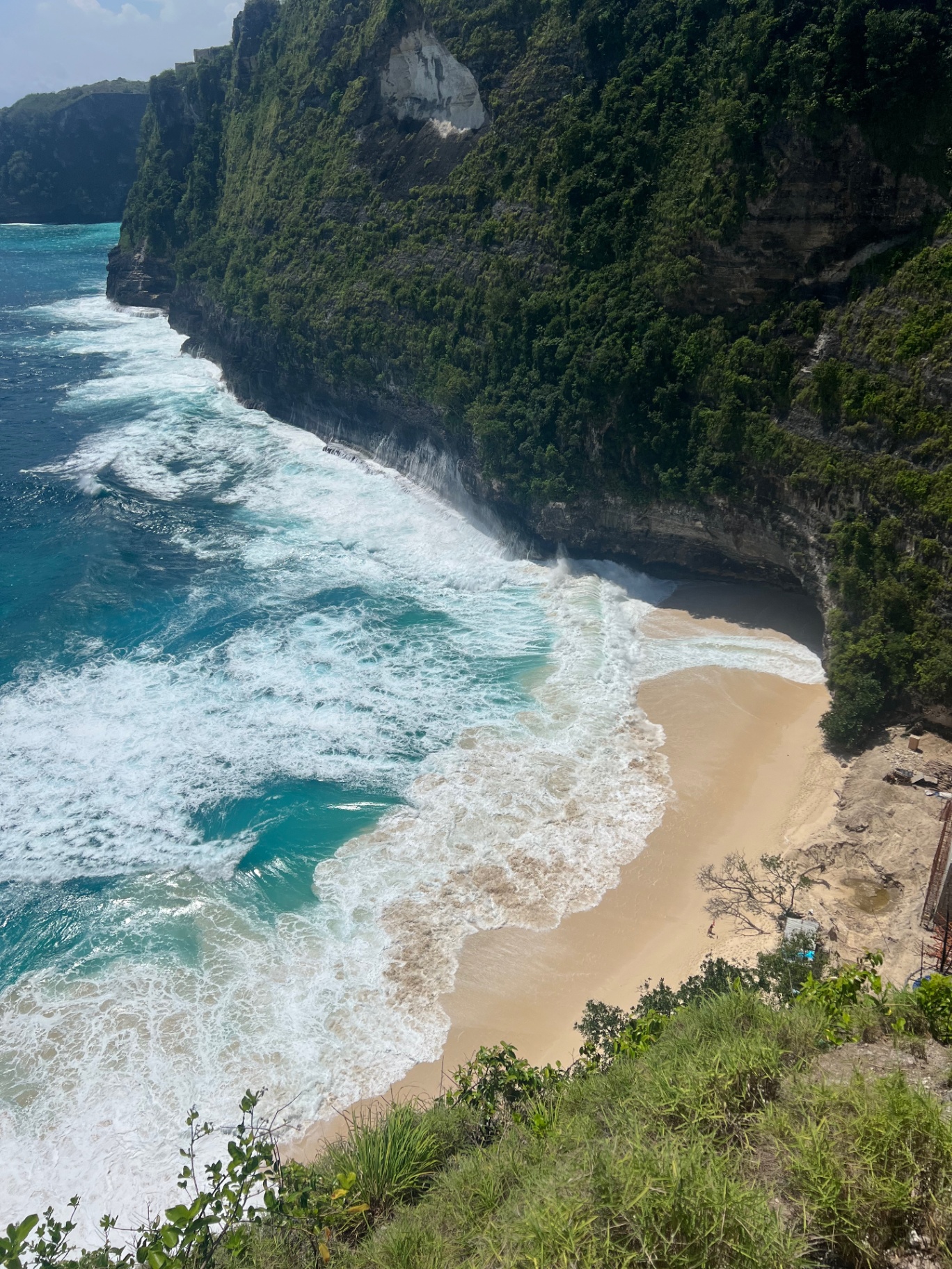 Nusa Penida — Hidden cove of golden sand below the towering Penida cliffs.