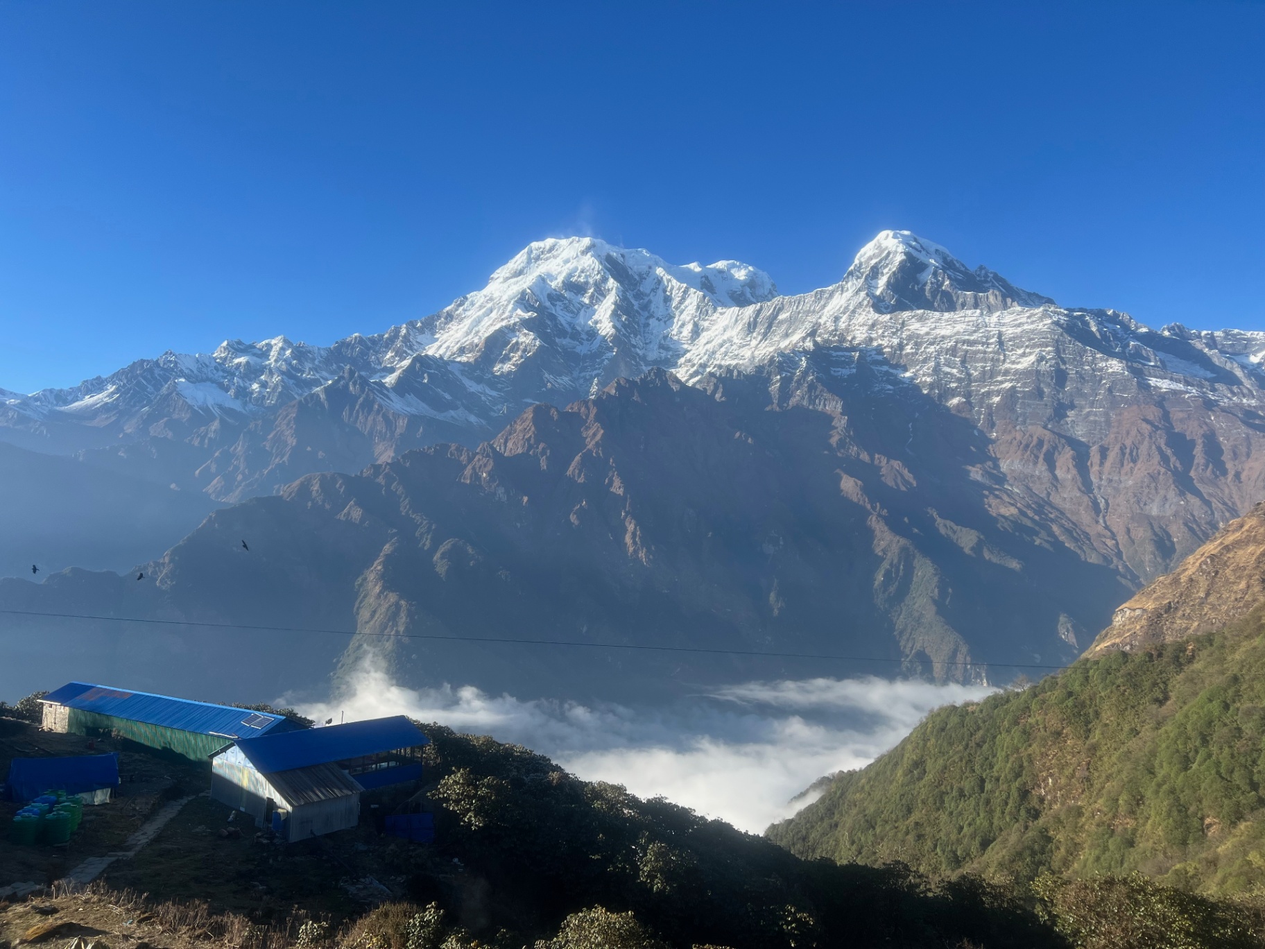 Pokhara — Morning sun on the Annapurnas with mist pooling in the valley.