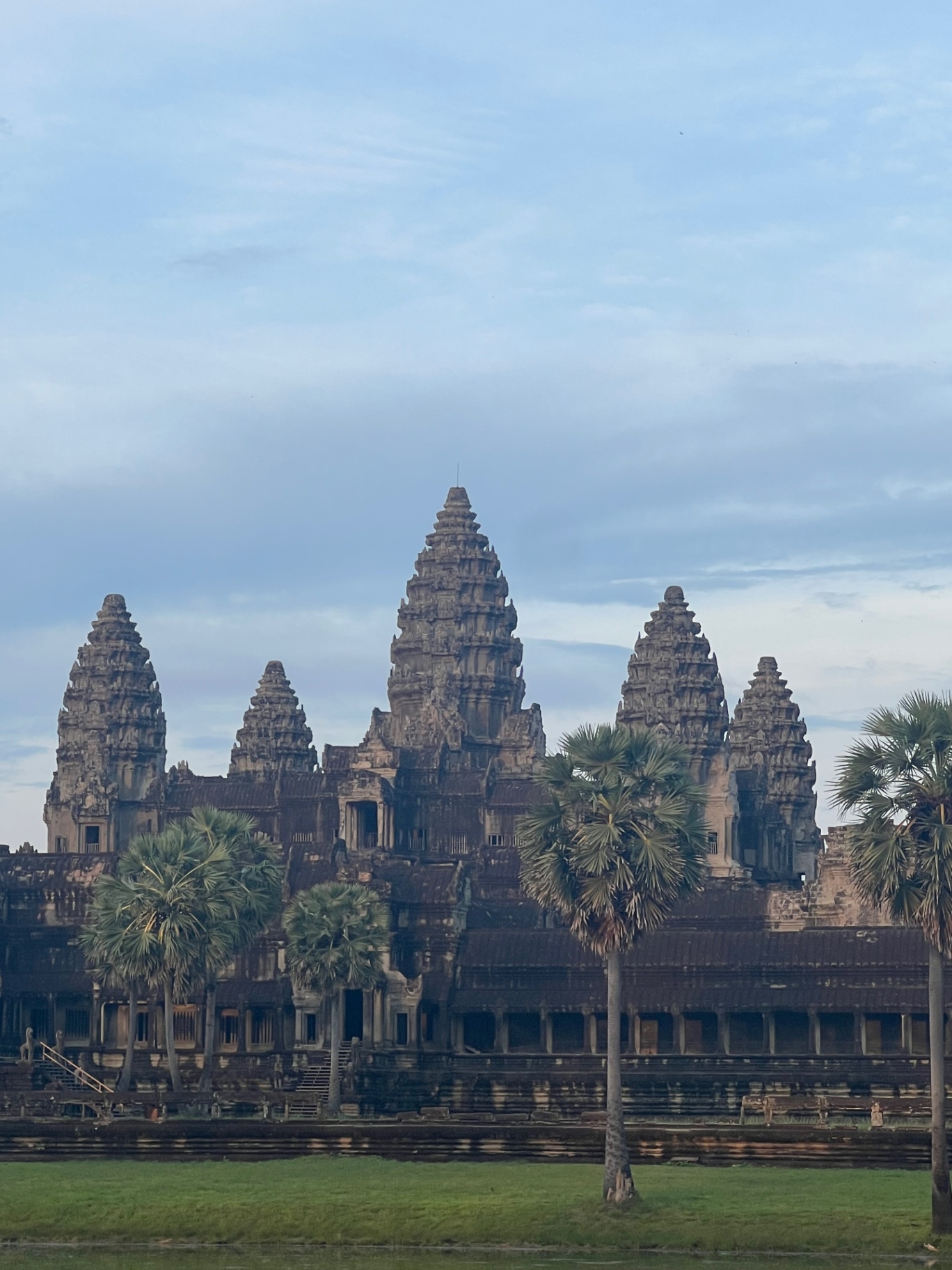 Siem Reap — The five towers of Angkor Wat lifted above the palms.
