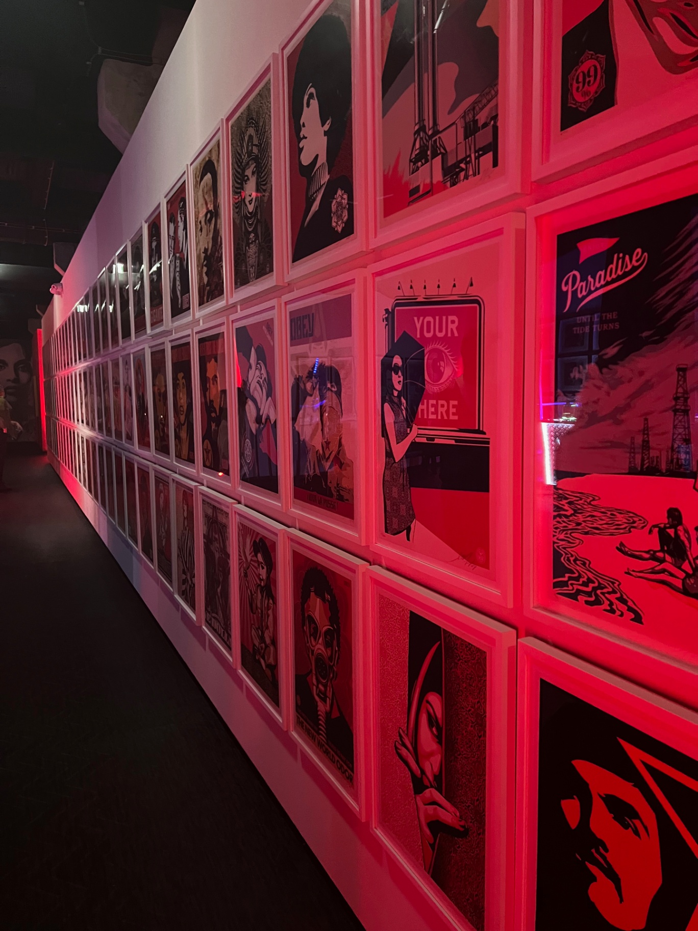 Tallinn — Wall of Shepard Fairey prints glowing red.