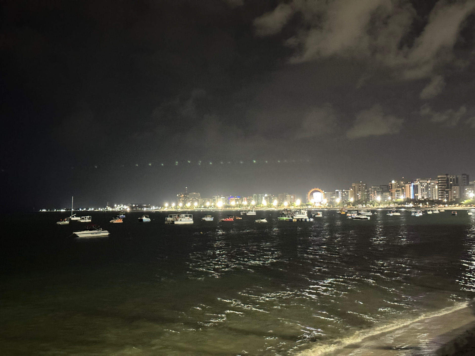 Maceio — Maceió's lit shoreline reflected on the water at night.