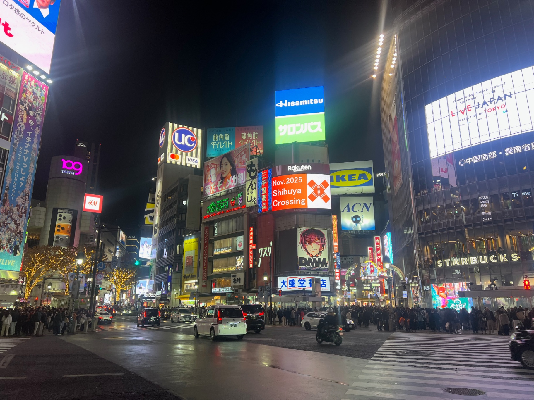 Tokyo — Shibuya Crossing under a canopy of glowing billboards and headlights.