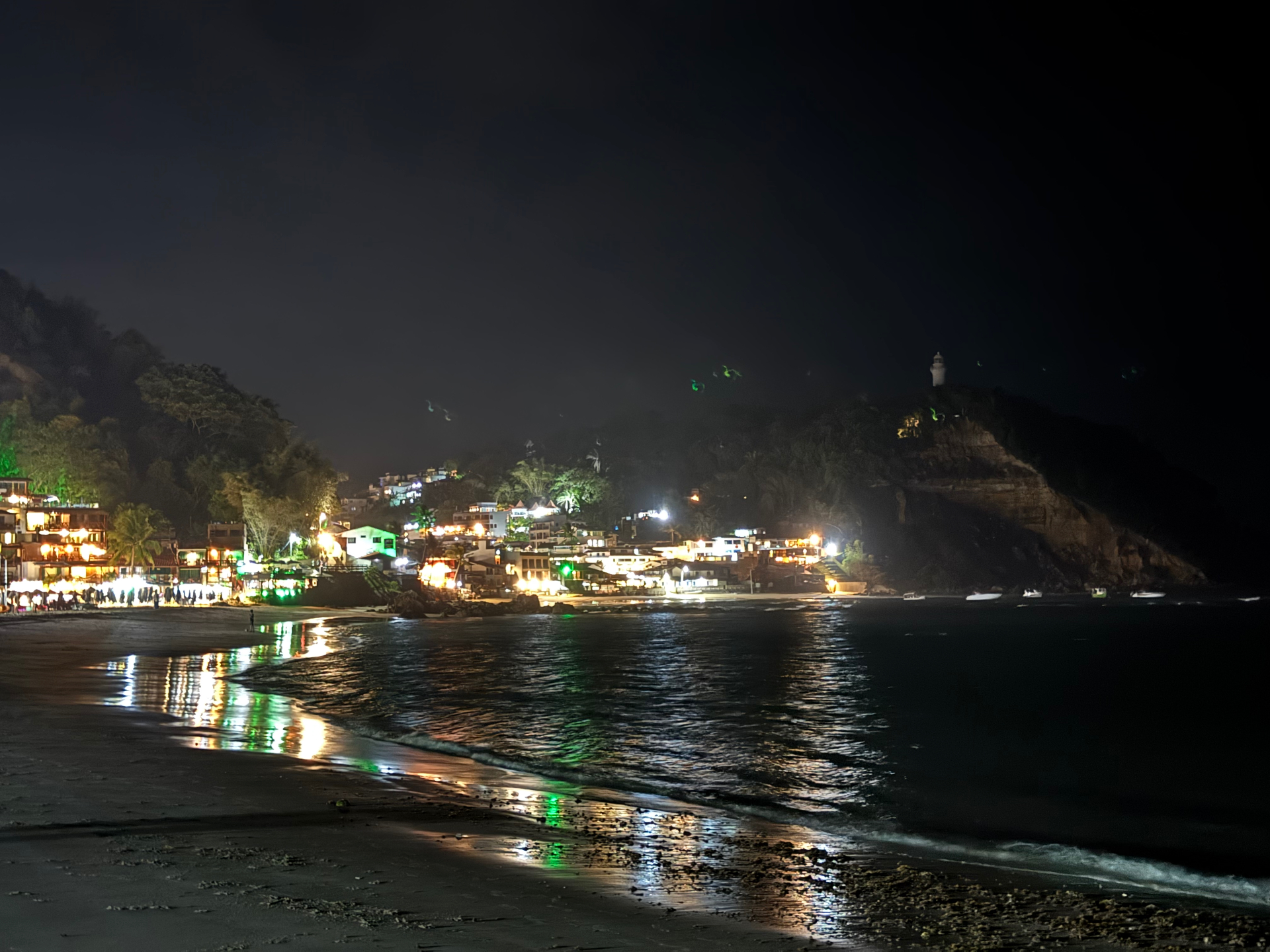 Morro de Sao Paulo — Night lights along the beach beneath the hillside lighthouse.