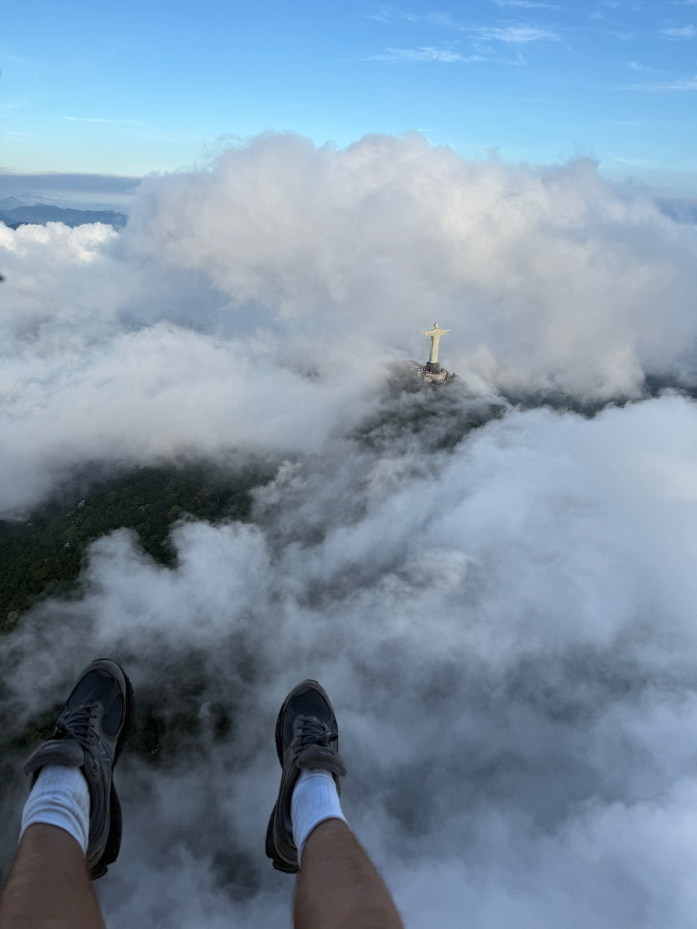 Rio de Janeiro — Feet over the clouds, Cristo Redentor below on a paraglide.